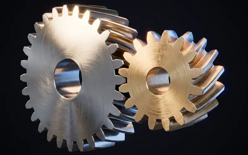 A helical gear pair in steel and brass seen from a steep angle, teeth fully engaged