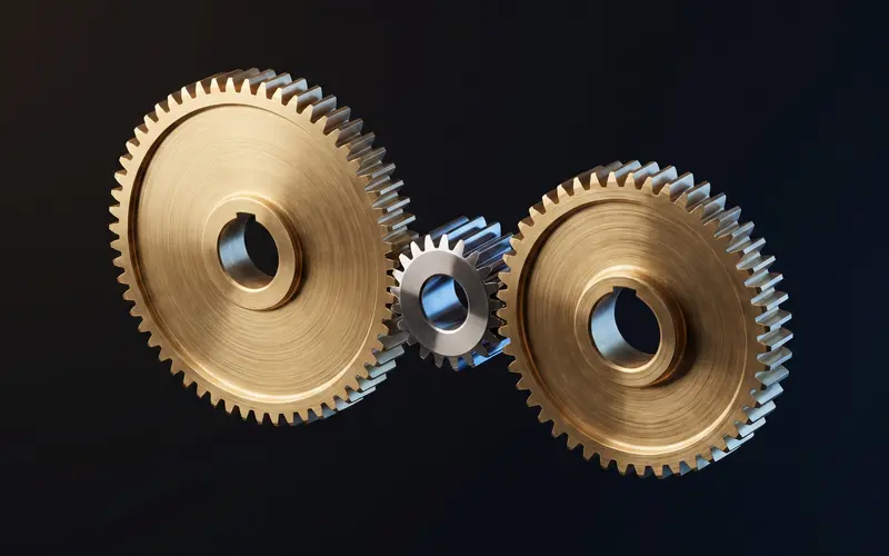 A three stage gear train: a brass wheel, a steel idler pinion and a second brass gear